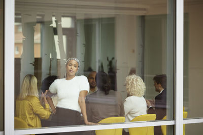 Businesswoman looking through office window during meeting