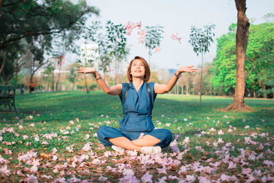 Portrait of a smiling young woman sitting in park