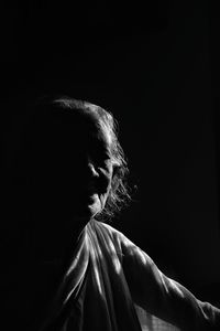 Side view of woman against black background