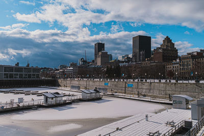 Buildings in city against cloudy sky