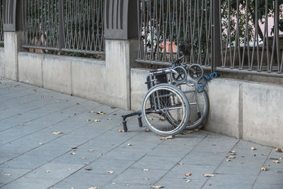 Bicycle parked on footpath by street against building