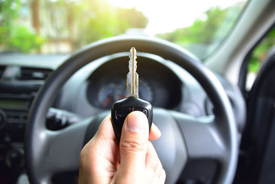 Cropped hand holding key in car