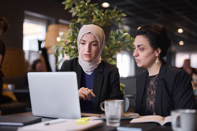 Businesswomen using laptop in cafe