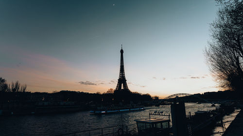 Bridge over river against sky at sunset