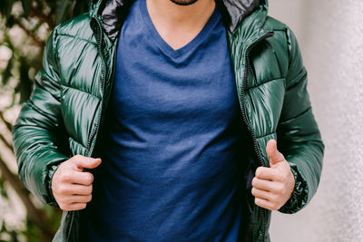 Midsection of man holding woman standing against blurred background