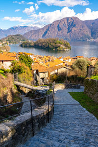 Comacina island, photographed in autumn, with trees, boats and piers around.