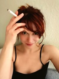 Portrait of young woman smoking cigarette