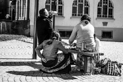 Rear view of woman with umbrella against built structure