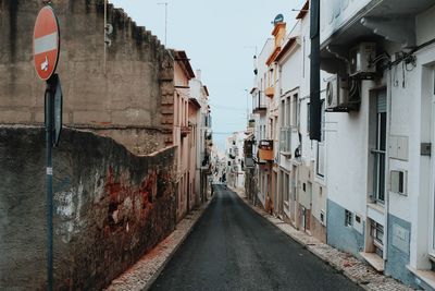 Narrow street amidst buildings against sky