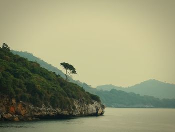 Scenic view of sea and mountains against clear sky