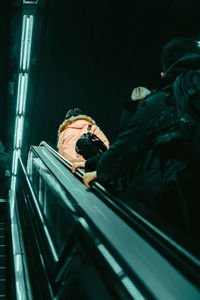 Rear view of man sitting on escalator