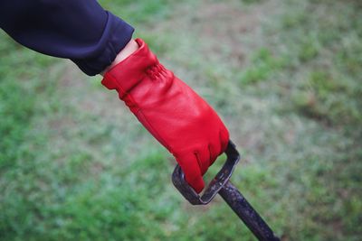 Close-up of person holding shovel on field