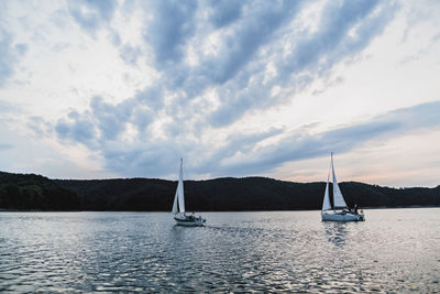 Sailboat sailing on sea against sky