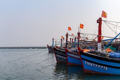 Fishing boat moored on sea against clear sky