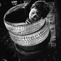 Boy sitting in pile of tires