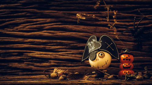 Close-up of pumpkin with toy on wood during halloween