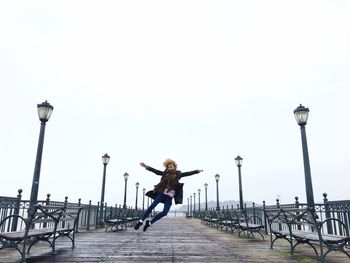 Woman jumping on pier