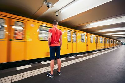 Rear view of woman standing in train