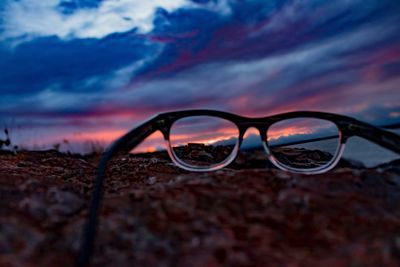 Close-up of eyeglasses against sky