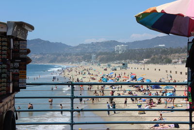 People on beach against sky in city