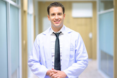 Portrait of businessman standing against wall