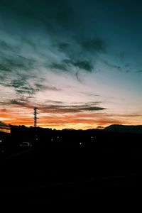 Silhouette landscape against dramatic sky during sunset