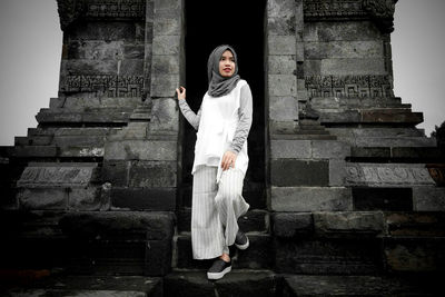 Full length of woman standing against building