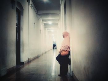 Rear view of woman standing in corridor