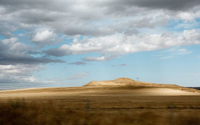 View of desert against cloudy sky