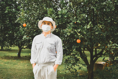 Full length of man standing against orange tree