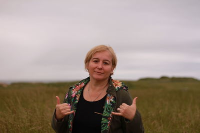 Portrait of woman standing on field against sky