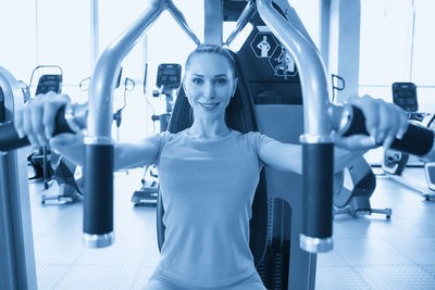 Portrait of young woman exercising in gym