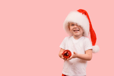 Boy standing against red background