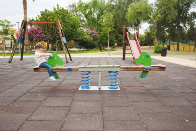 Full length of boy swinging in playground