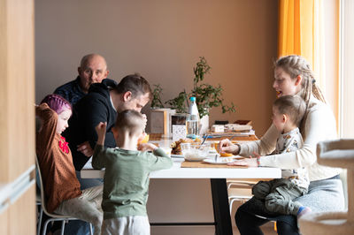 Multi generation family eating meal around kitchen table