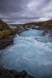 Scenic view of waterfall against sky