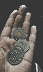 Close-up of hand holding coins