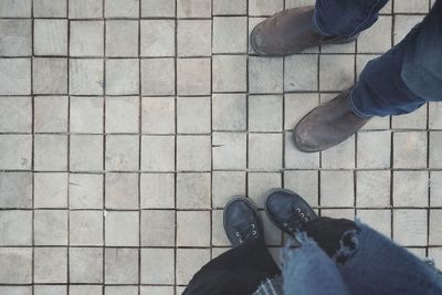 Low section of people standing on tiled floor