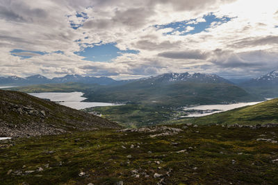 Scenic view of clouds over mountains and sea