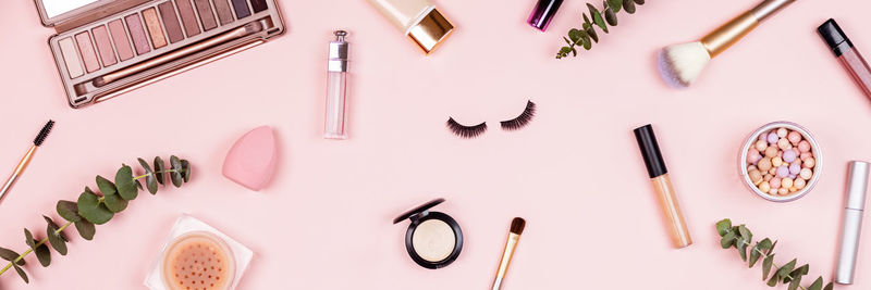 Directly above shot of beauty products over pink background