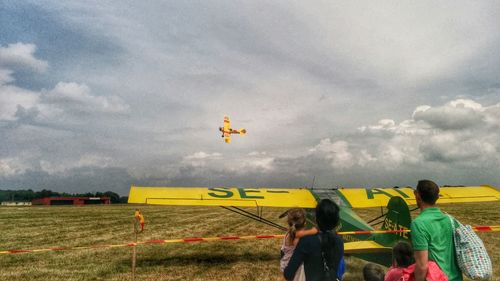 Person standing on field against cloudy sky