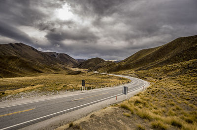 Road by mountain against sky