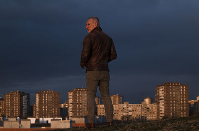 Adult man looking at city skyline of madrid, spain, during sunset