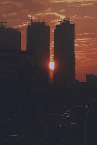 Silhouette cityscape against sky during sunset