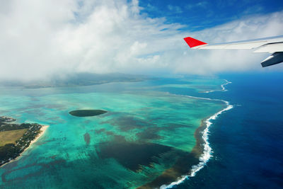 Aerial view of seascape against cloudy sky