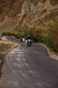 People riding motorcycle on road