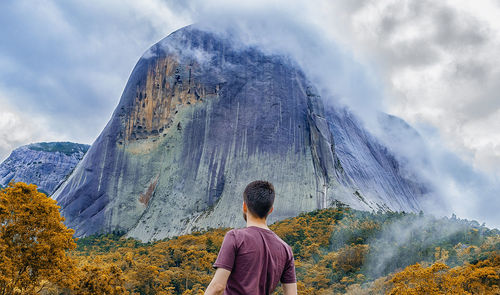 Rear view of woman looking at mountain against sky