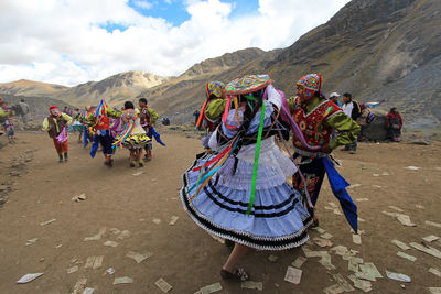 People dancing on mountain road against sky