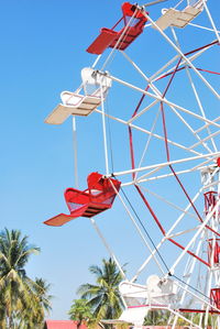 Low angle view of ferris wheel against clear blue sky