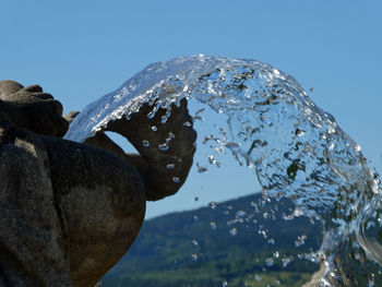 Close-up of wet rock against sky during winter